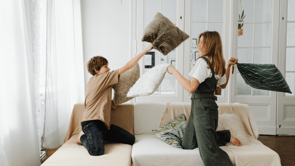 two people sitting on a couch with pillows