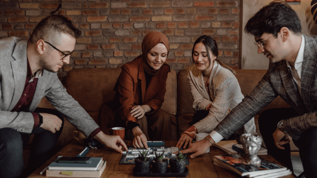 Four people sitting around a table playing a board game