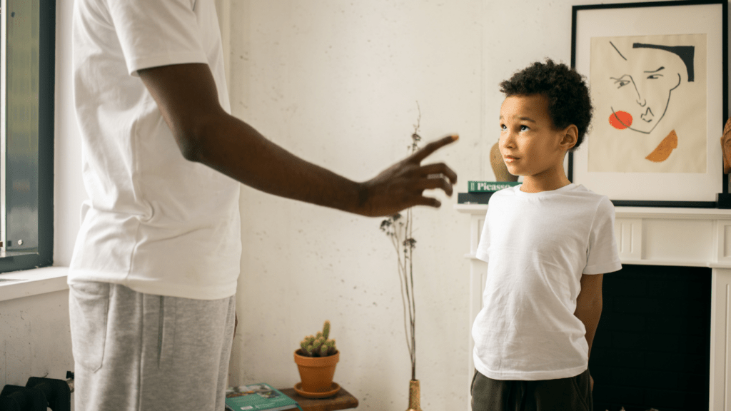 A man talking to a young boy in a living room