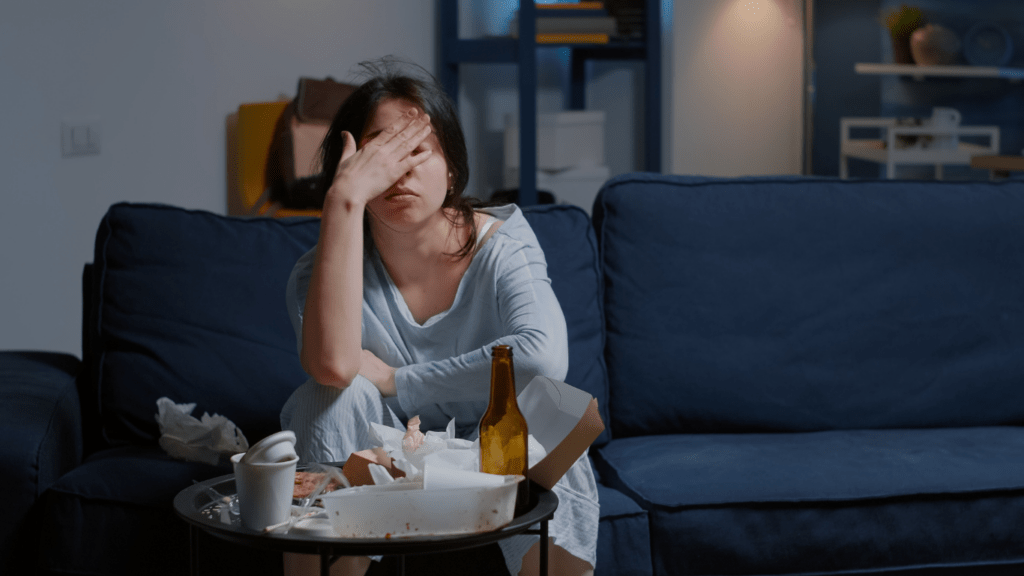 a person is sitting at a desk with their head in their hands