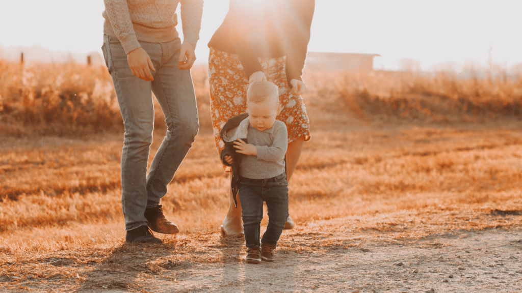 Two people holding hands with a child