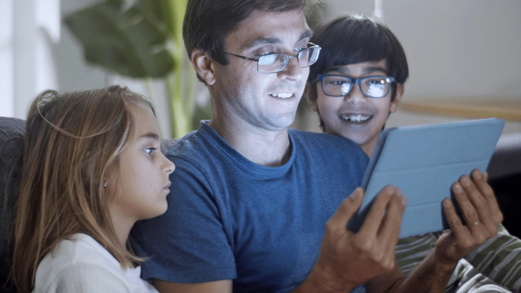  children sitting on a couch with their cell phones