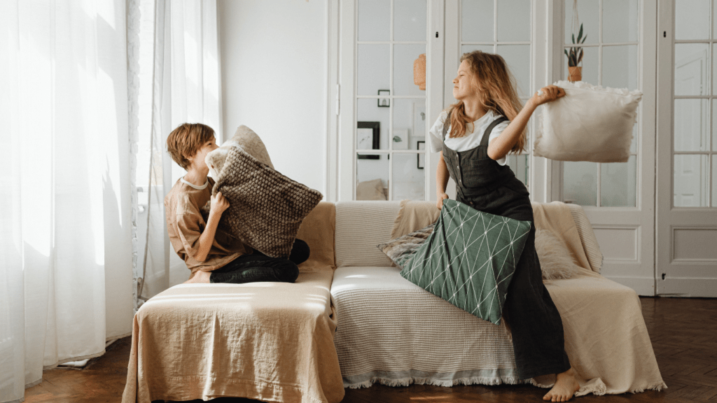 two people sitting on a couch with pillows